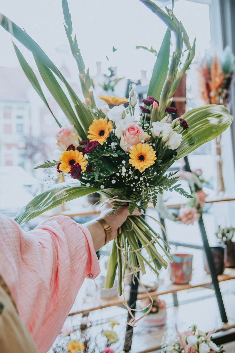 Hand-tied bouquet of garden roses and ranunculus in soft pink and cream tones